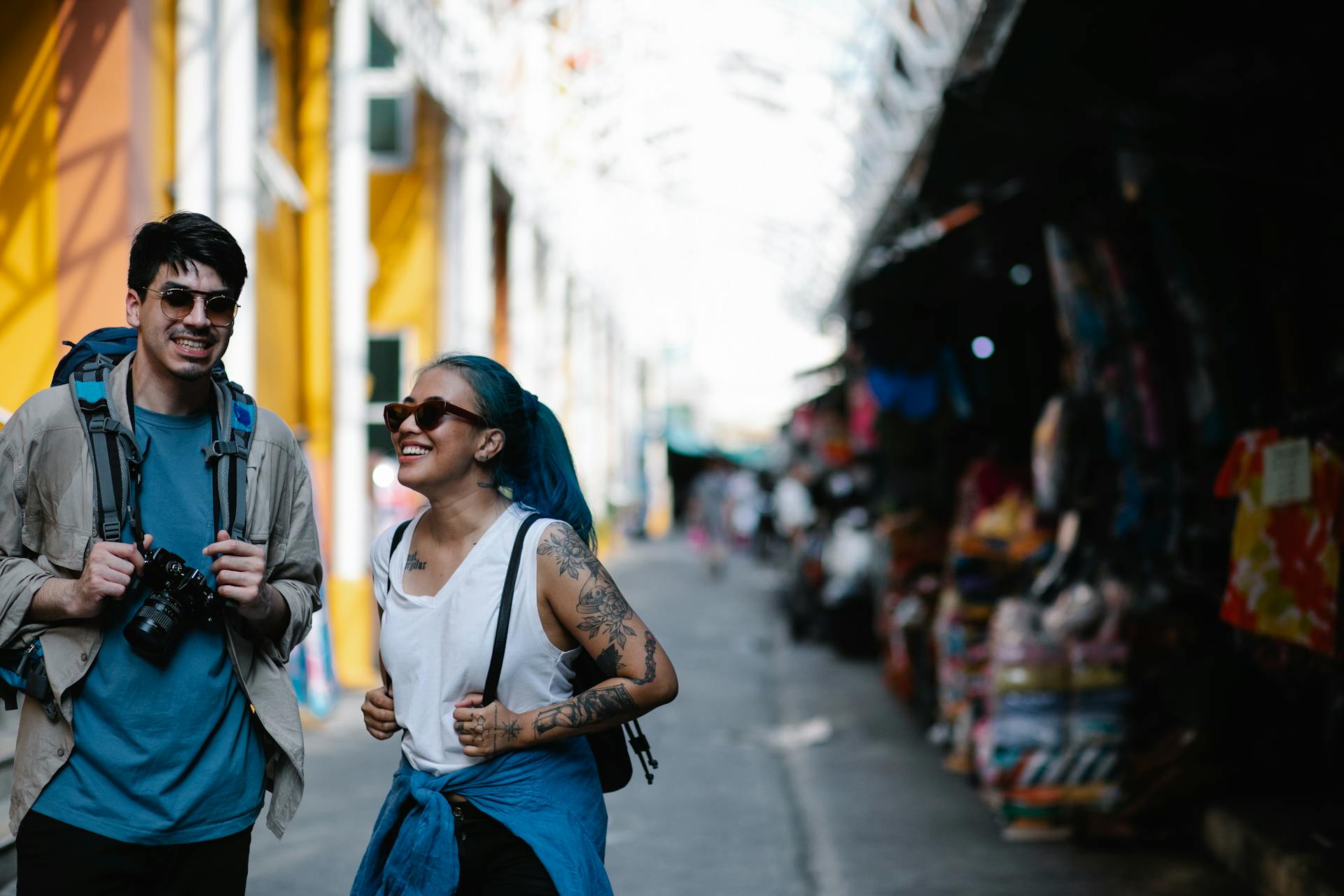 A joyful couple walking through a lively market, enjoying their travel adventure.