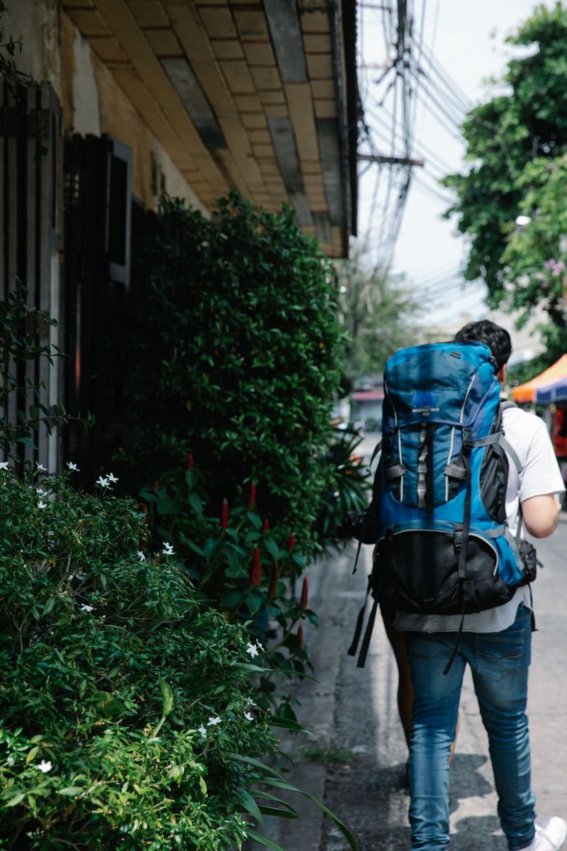 Traveller crossing a bridge with a backpack — photo by George Pak on Pexels