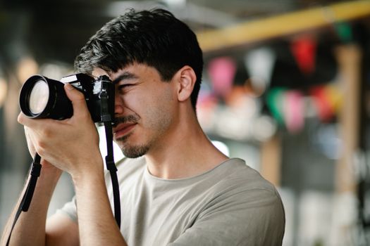 Focused photographer using a DSLR camera, capturing candid moments indoors.