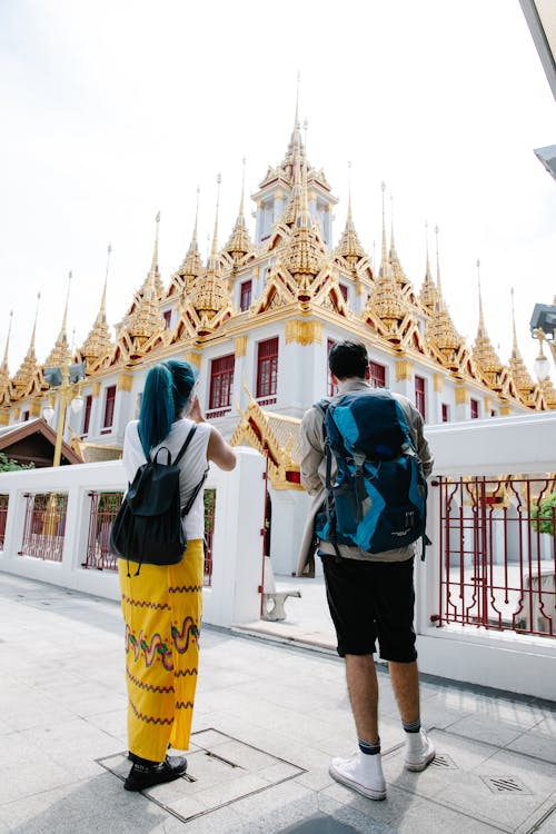 Free Man and Woman Standing in Front of Buddhist Temple in Bangkok Thailand  Stock Photo