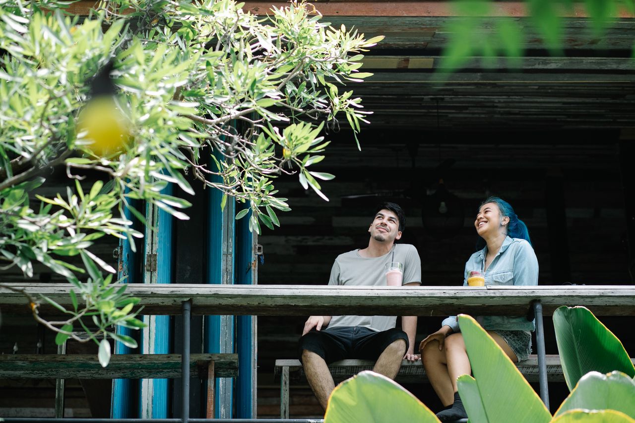 two friends sitting together outdoors enjoying refreshing drinks and l