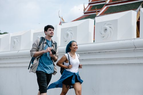 Free A cheerful couple exploring an outdoor landmark with traditional architecture. Stock Photo