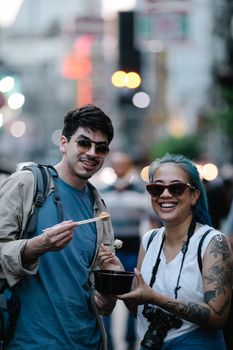 Tourists enjoying street food in an urban setting, capturing the joy of culinary exploration.