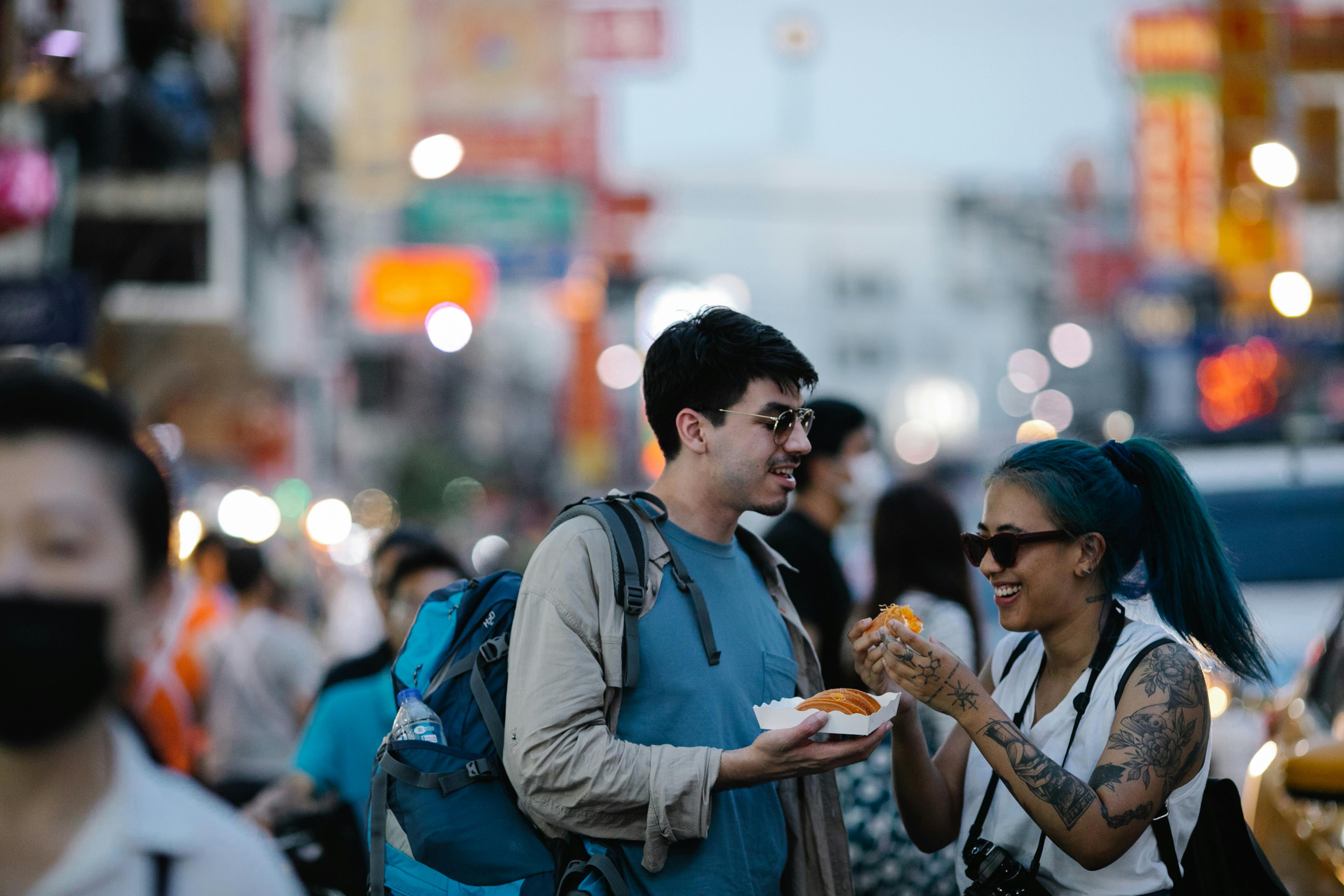 two tourists eating street food