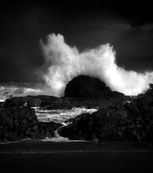 Free Powerful black and white image of ocean waves crashing against rocks in Riverton, Southland, New Zealand. Stock Photo