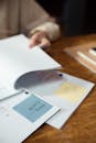 Person Holding White Paper on Brown Table