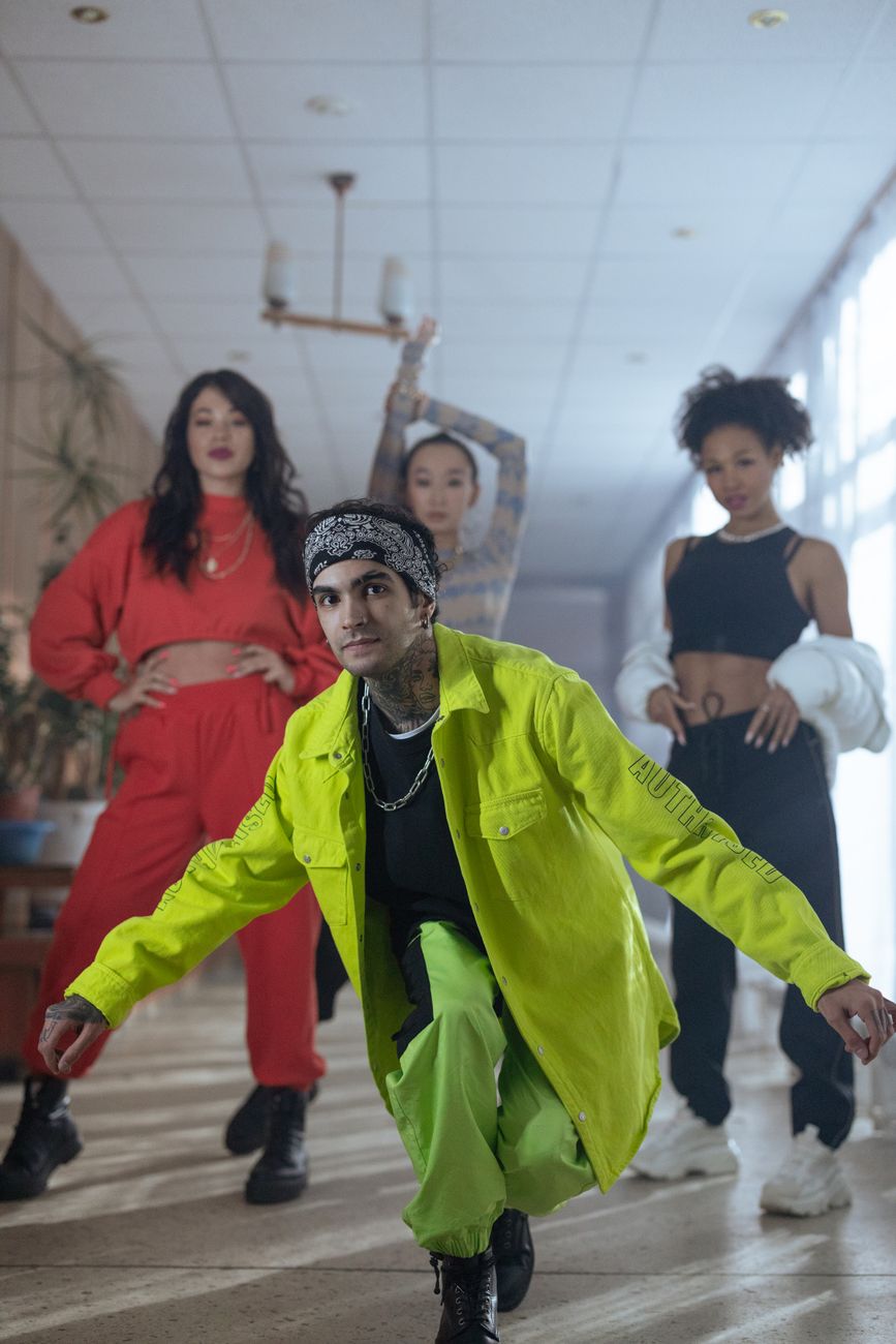 A diverse group showcasing hip hop fashion and dynamic poses indoors.