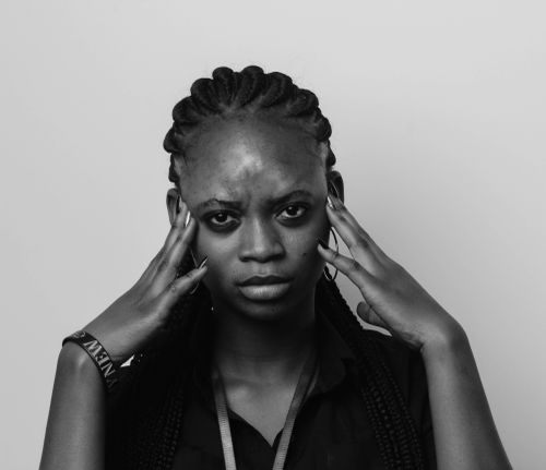 Free A striking black and white portrait of a woman with braids focusing intensely at the camera. Stock Photo
