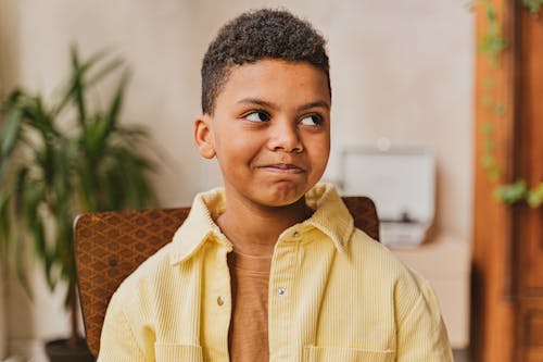 Free Selective Focus Photo of a Boy in a Yellow Shirt Looking Away Stock Photo