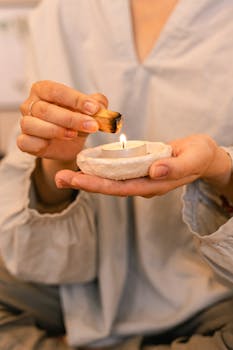 Relaxing scene of a person lighting a candle with sage for a peaceful ritual.