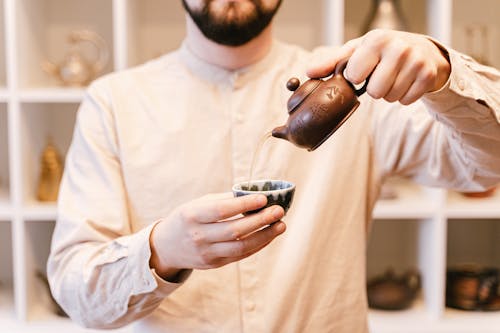 Man Pouring Tea in a Cup