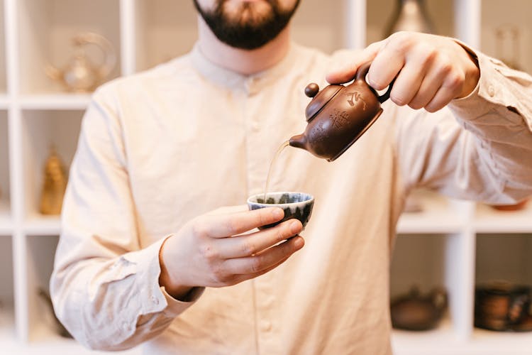 Man Pouring Tea In A Cup