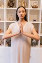 Woman Folding Her Hands with White Wooden Shelf at the Back