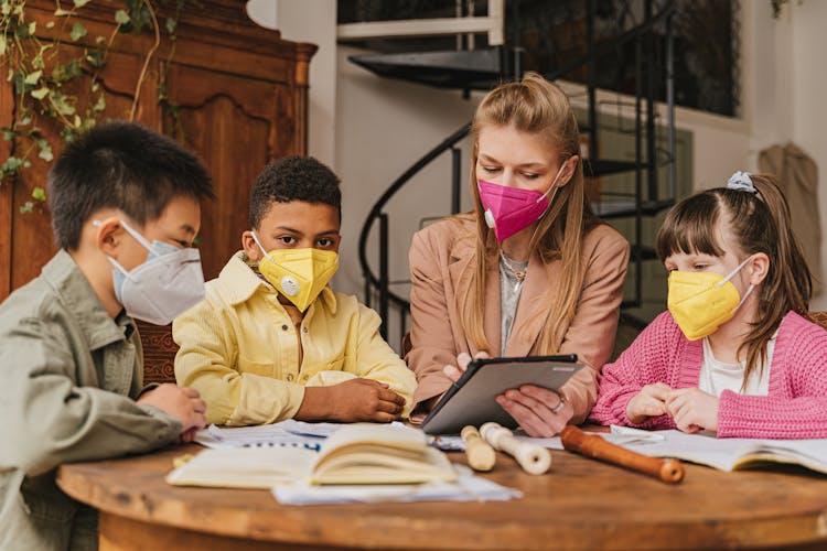 Woman Holding A Tablet Beside Children