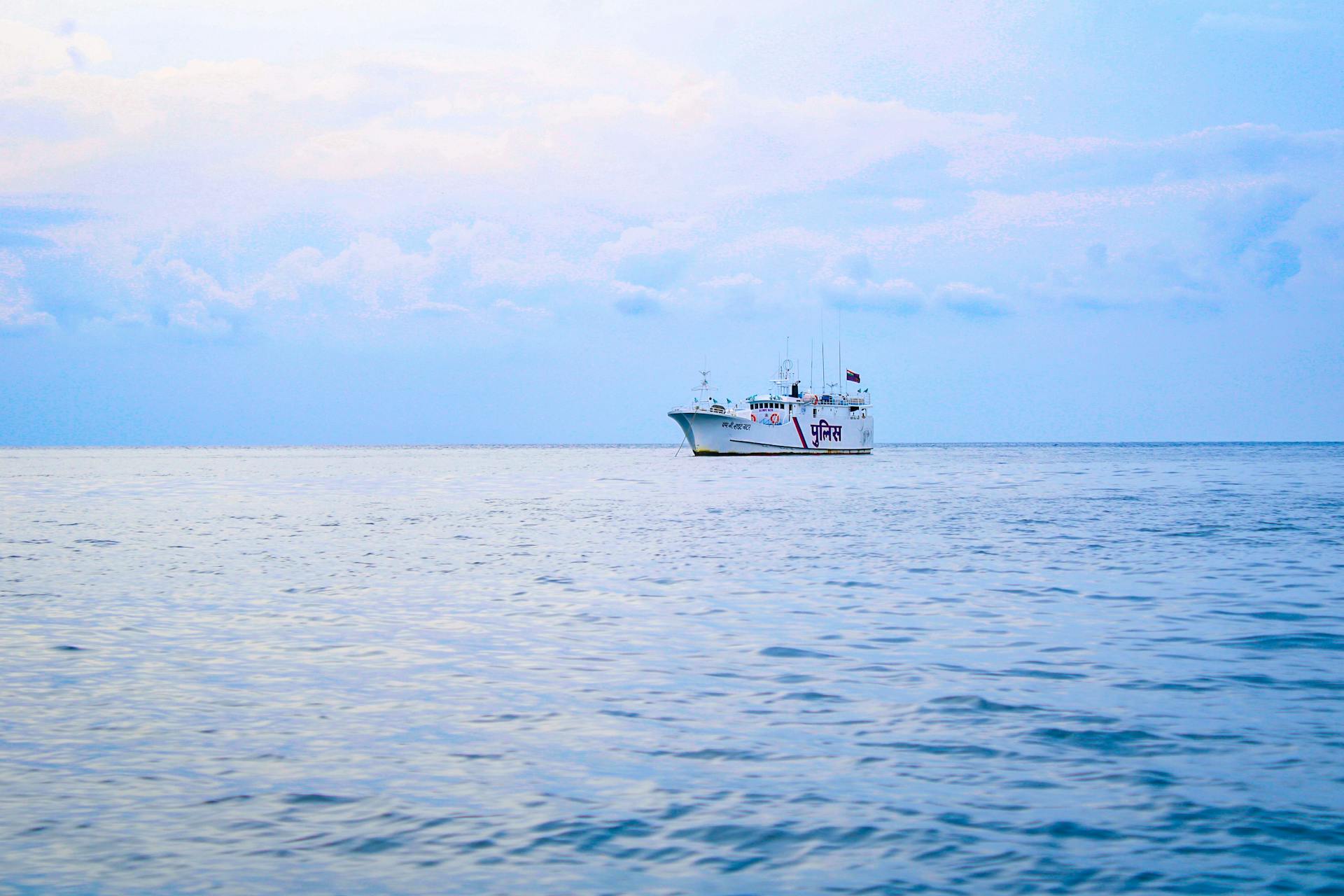 A serene scene of a coast guard vessel on the calm waters of the Indian Ocean under a clear sky.