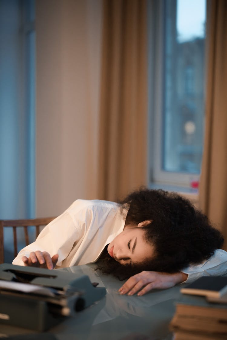 Tired Woman Leaning On The Table