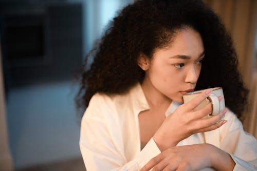 Woman with Curly Hair Drinking from a Mug
