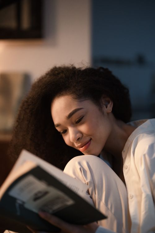 Free A woman enjoys peaceful reading indoors, creating a cozy and calm atmosphere. Stock Photo