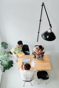 Group of coworkers in a modern office space collaborating during a team meeting.