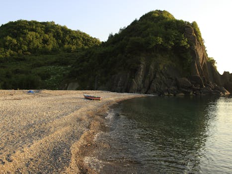 Serene beach with a lone rowboat by the rocky shore in Cide, Türkiye.