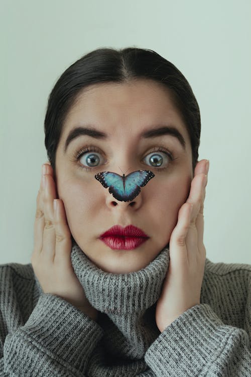 Close-Up Shot of a Woman with a Butterfly on Her Nose 