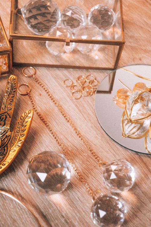 Free A stylish arrangement of crystal and gold jewelry on a wooden surface. Stock Photo