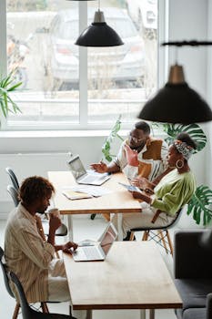 A group of professionals working and discussing ideas in a bright, contemporary office setting.