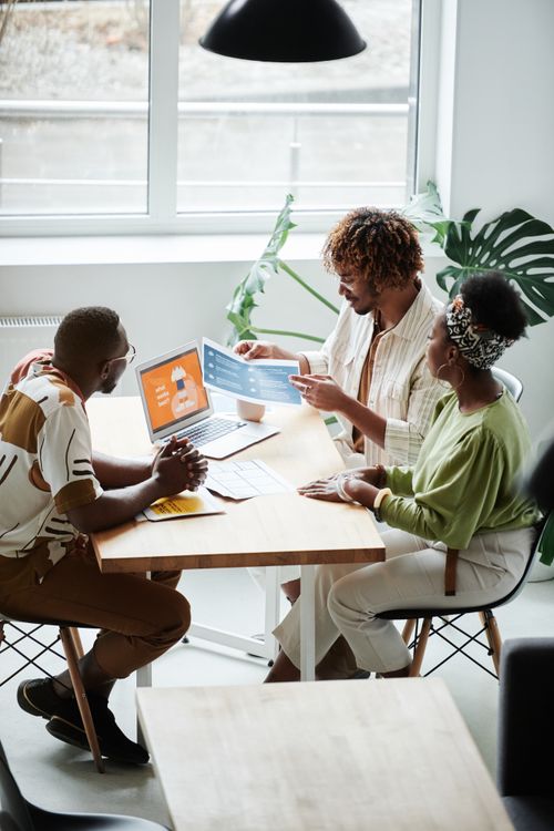 Free A diverse team engaged in a collaborative business meeting in a bright, modern office setting. Stock Photo
