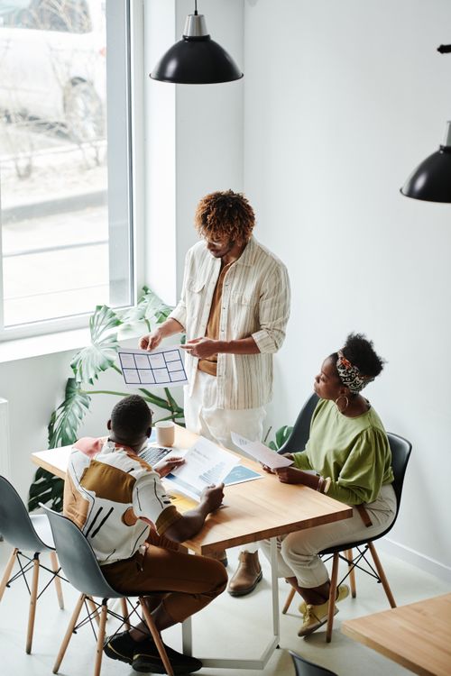 Free A diverse team of professionals engaged in a productive brainstorming session in a modern office setting. Stock Photo