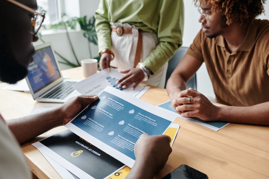 Photo by Darlene Alderson on Pexels Team of professionals collaborating on business reports at office desk.
