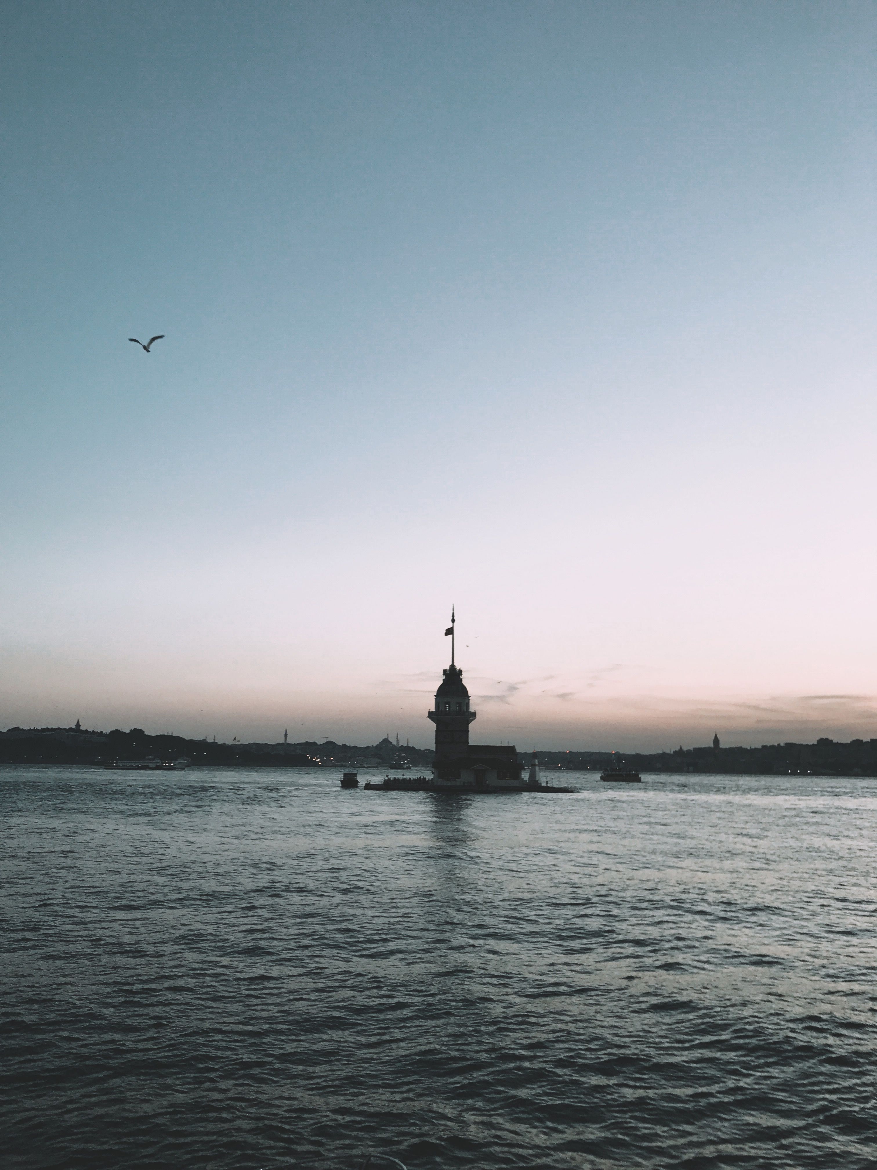 Red and White Lighthouse Near Body of Water · Free Stock Photo