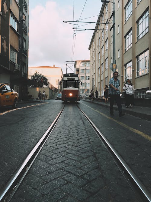 Tramway with glowing headlight riding on rails