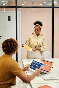 A diverse team discussing business plans in an office setting, making use of digital tools.