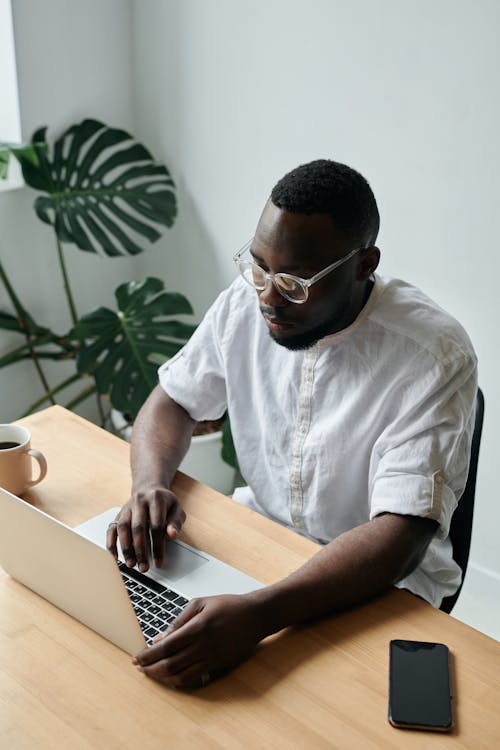 Free Man in White Button Up Shirt Using a Laptop Stock Photo