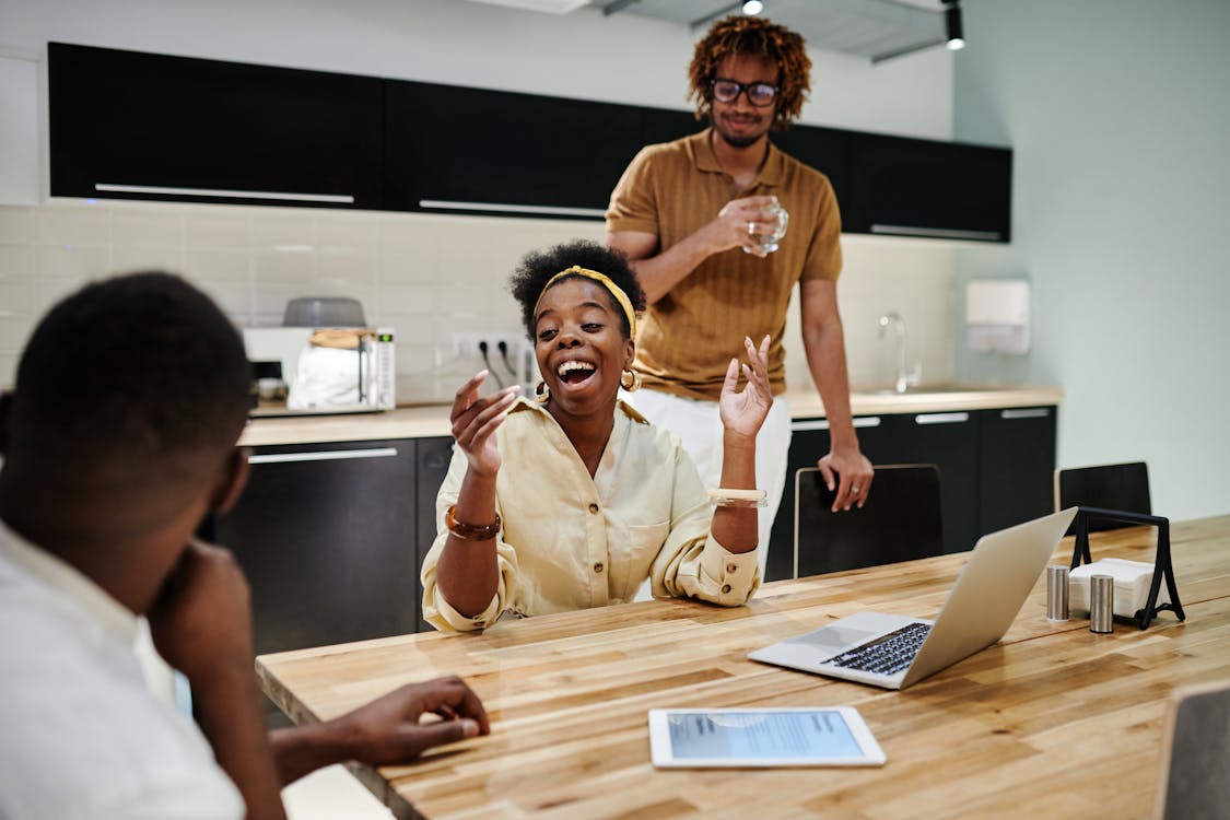 People in the Modern Office Kitchen with Wooden Table