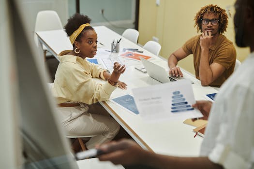 A diverse team collaborating and discussing business strategies over a meeting table.