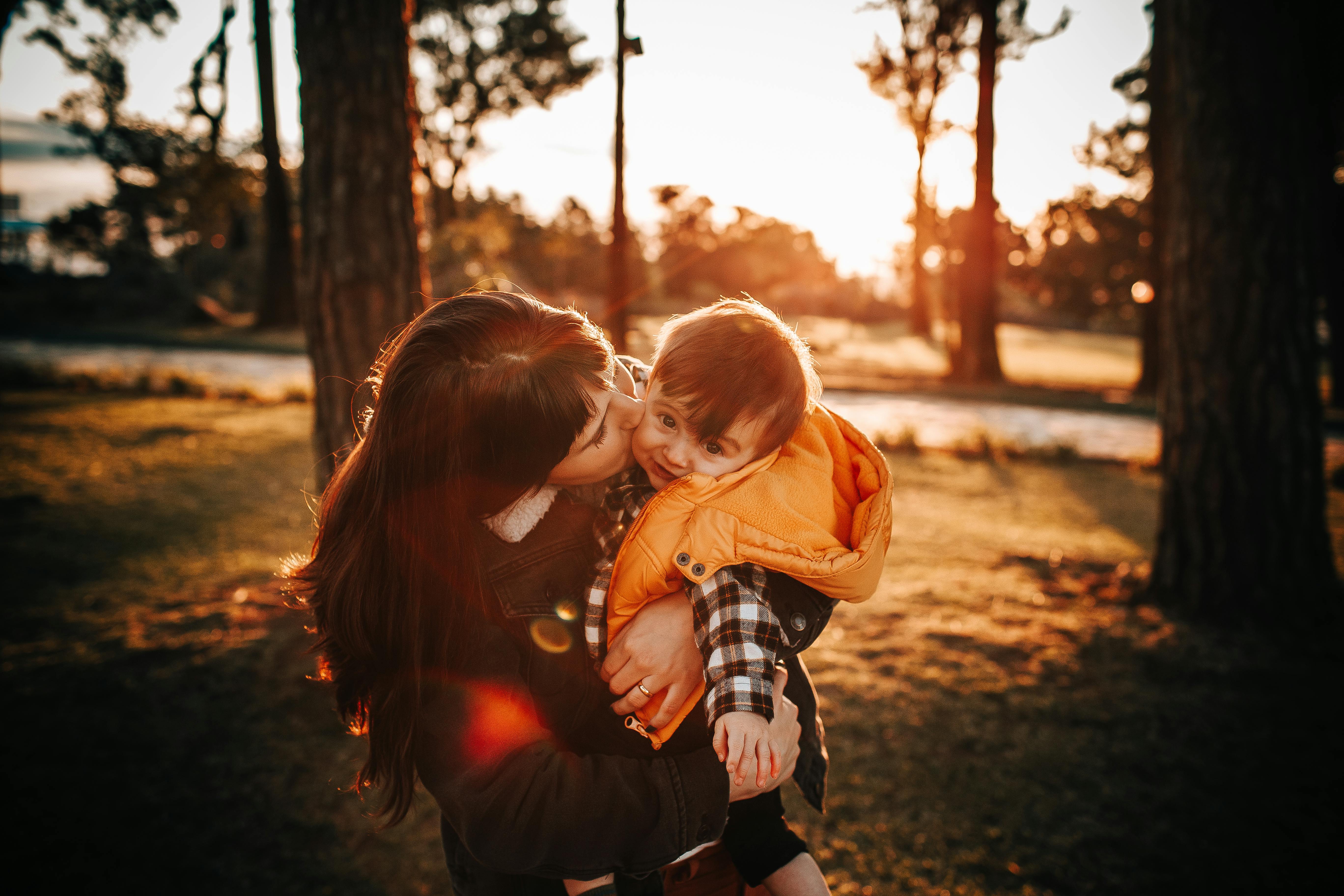 a mother kissing her son