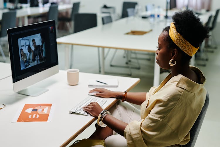 A Woman In Yellow Long Sleeves Using A Computer In The Office