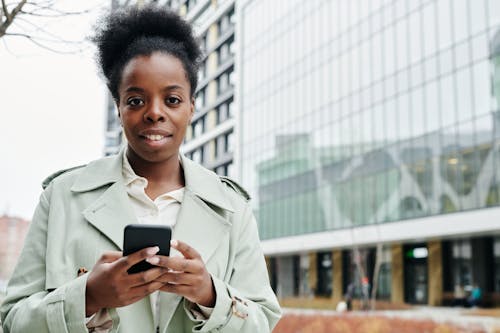 A Woman in Beige Blazer using a Smartphone