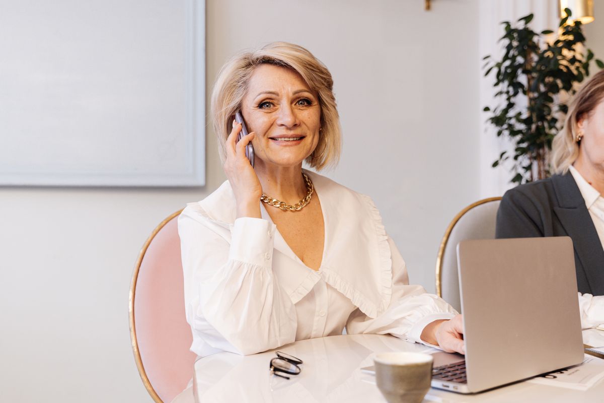 Senior woman smiling on phone in office