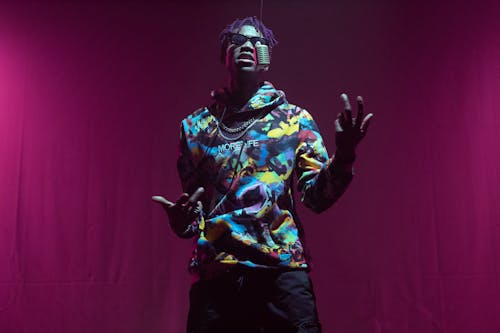 Man in Colorful Hoodie Standing on Stage