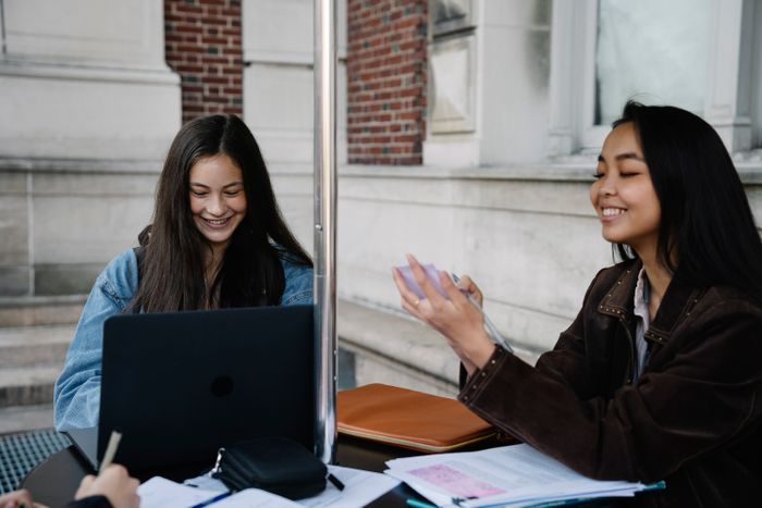 Two students studying together outside the library