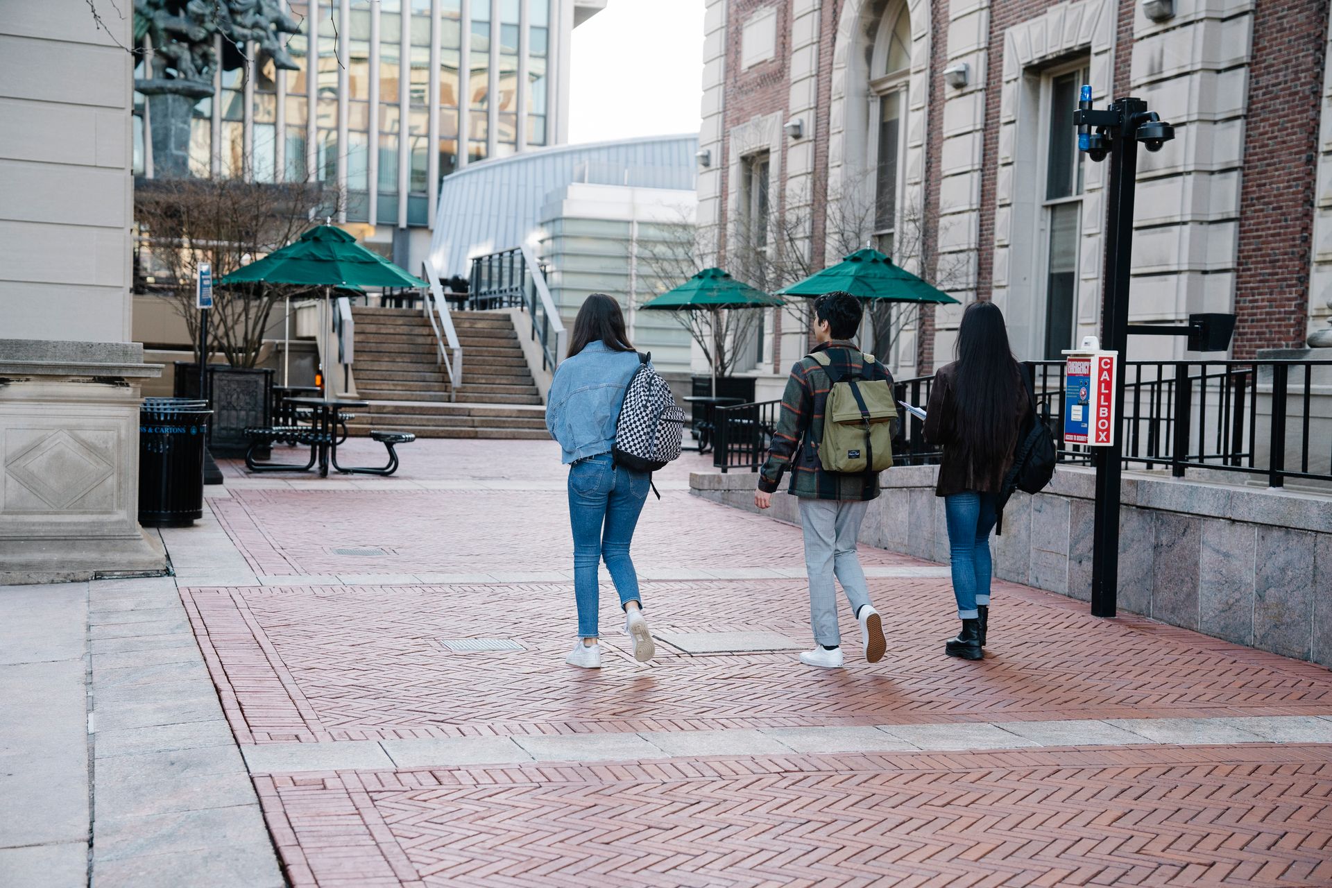 A group of students leisurely walking on a university campus pathway during the day.