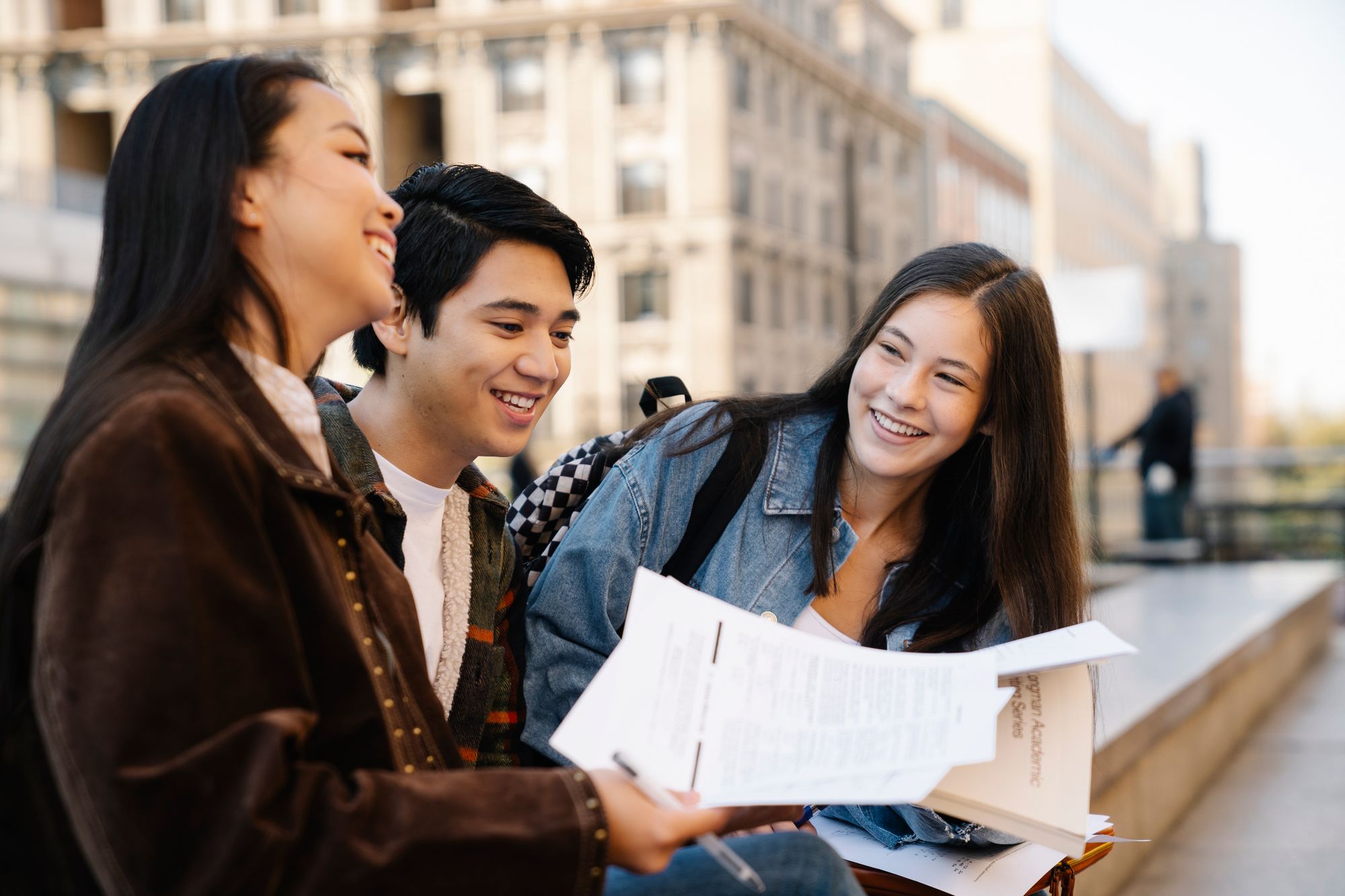 A group of students sitting on a concrete bench