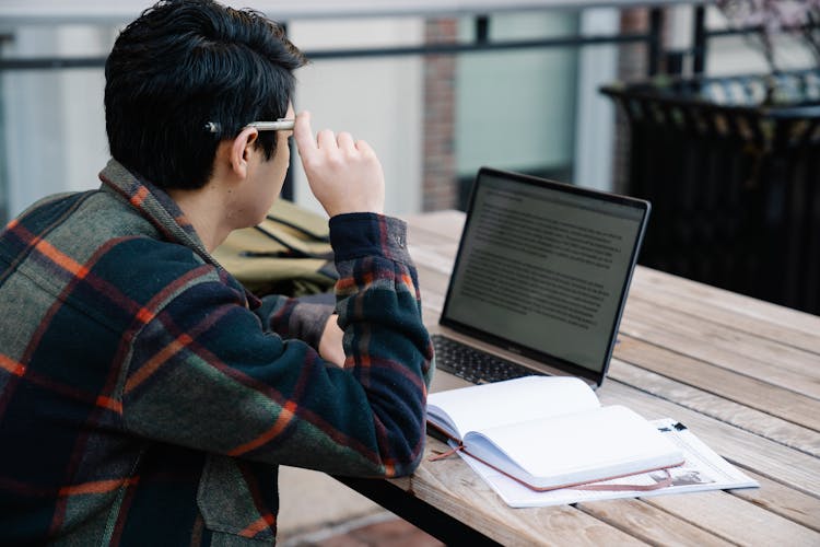 Photo Of A Man Reading On His Laptop