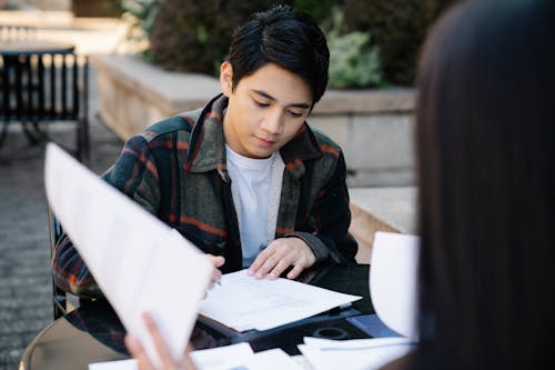 Photo of a Man in a White Inner Shirt Studying 