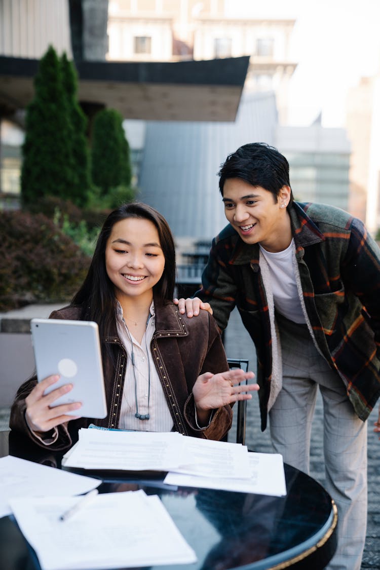 Man And Woman Looking At An An Ipad