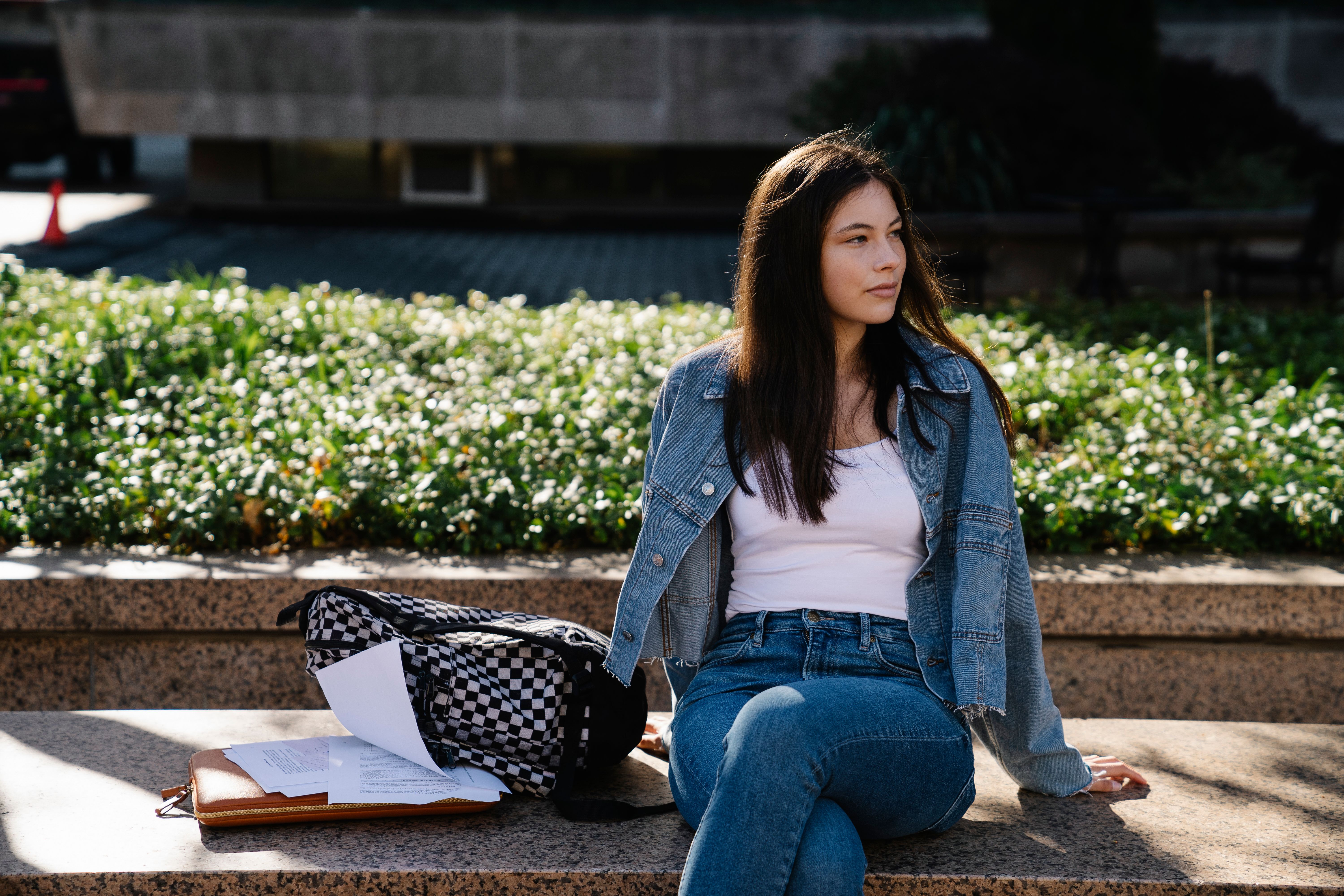 Woman in Blue Denim Jacket and Blue Denim Jeans Sitting on Concrete ...