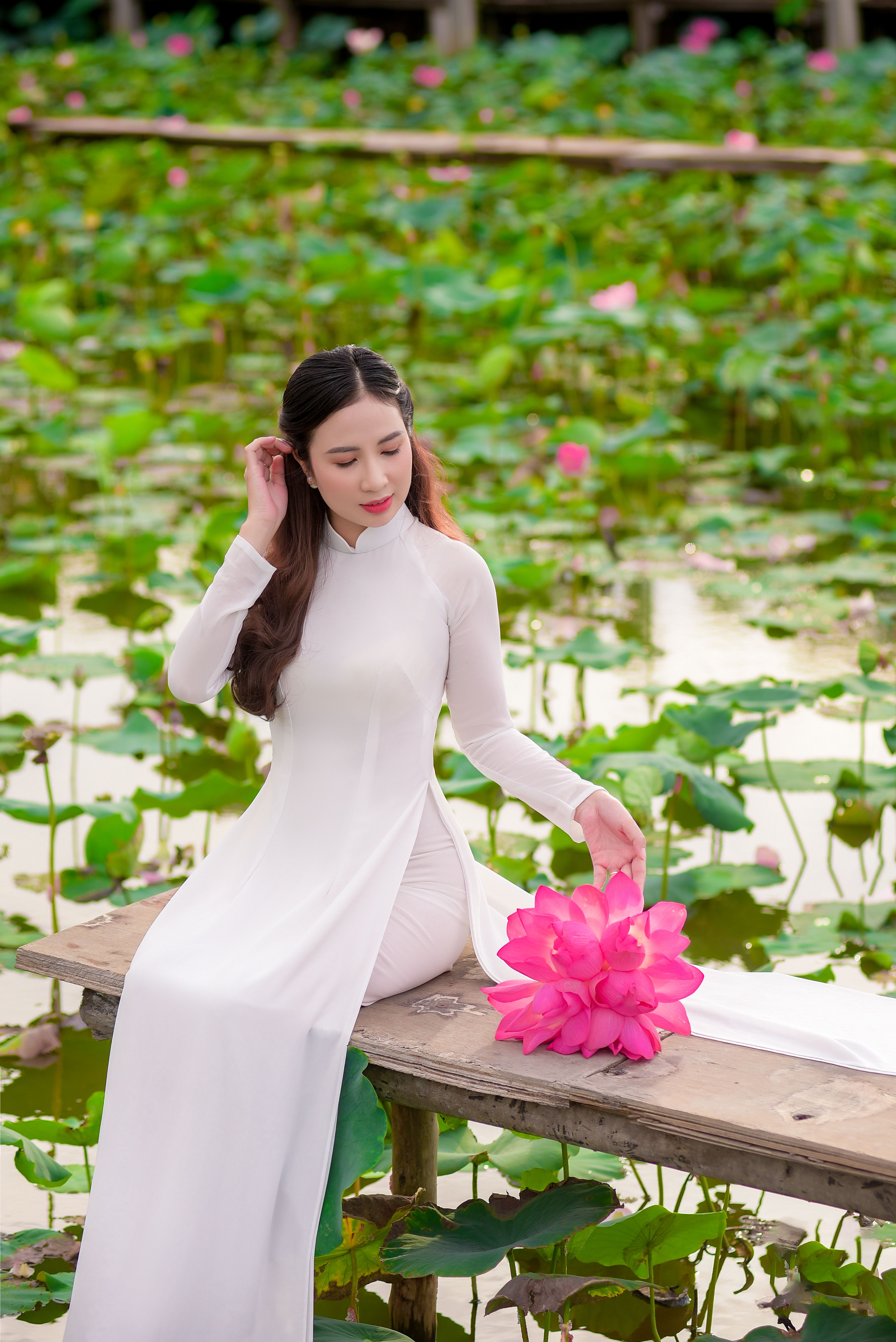 Photo of a Woman in a White Dress Sitting Near a Pond · Free Stock Photo