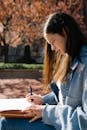 Woman in Blue Denim Jacket Holding Smartphone